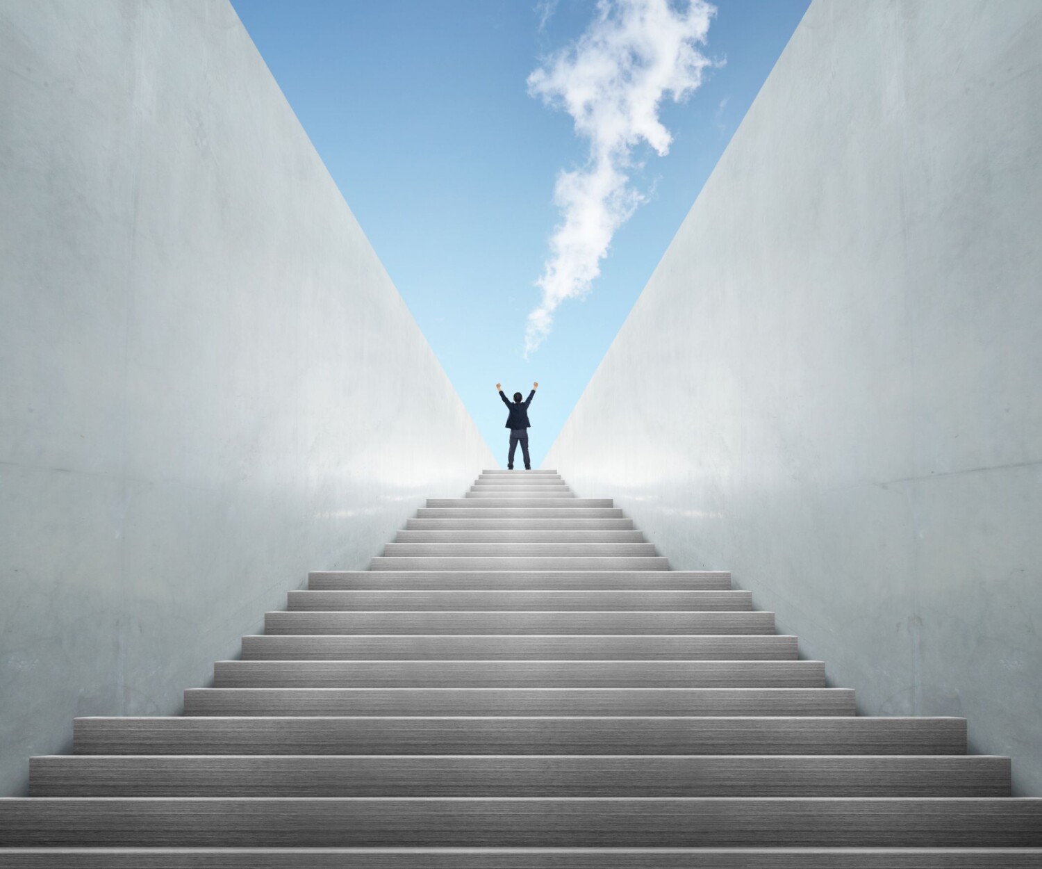Man with hands in the air on top of stairs